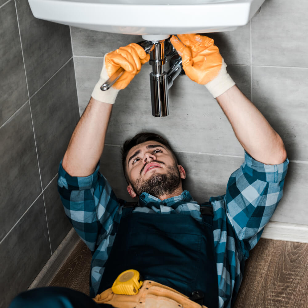 image of handyman fixing a leaking sink